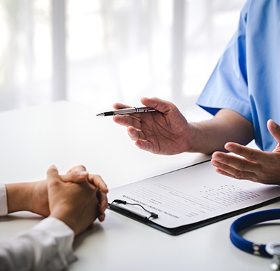 Doctor and patient, sitting at desk and talking