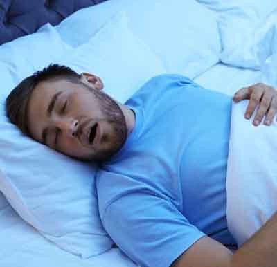 Young man snoring in bed