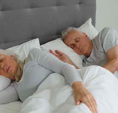 Older couple sleeping in bed