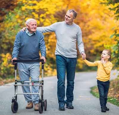 Grandfather, father, and child walking outside